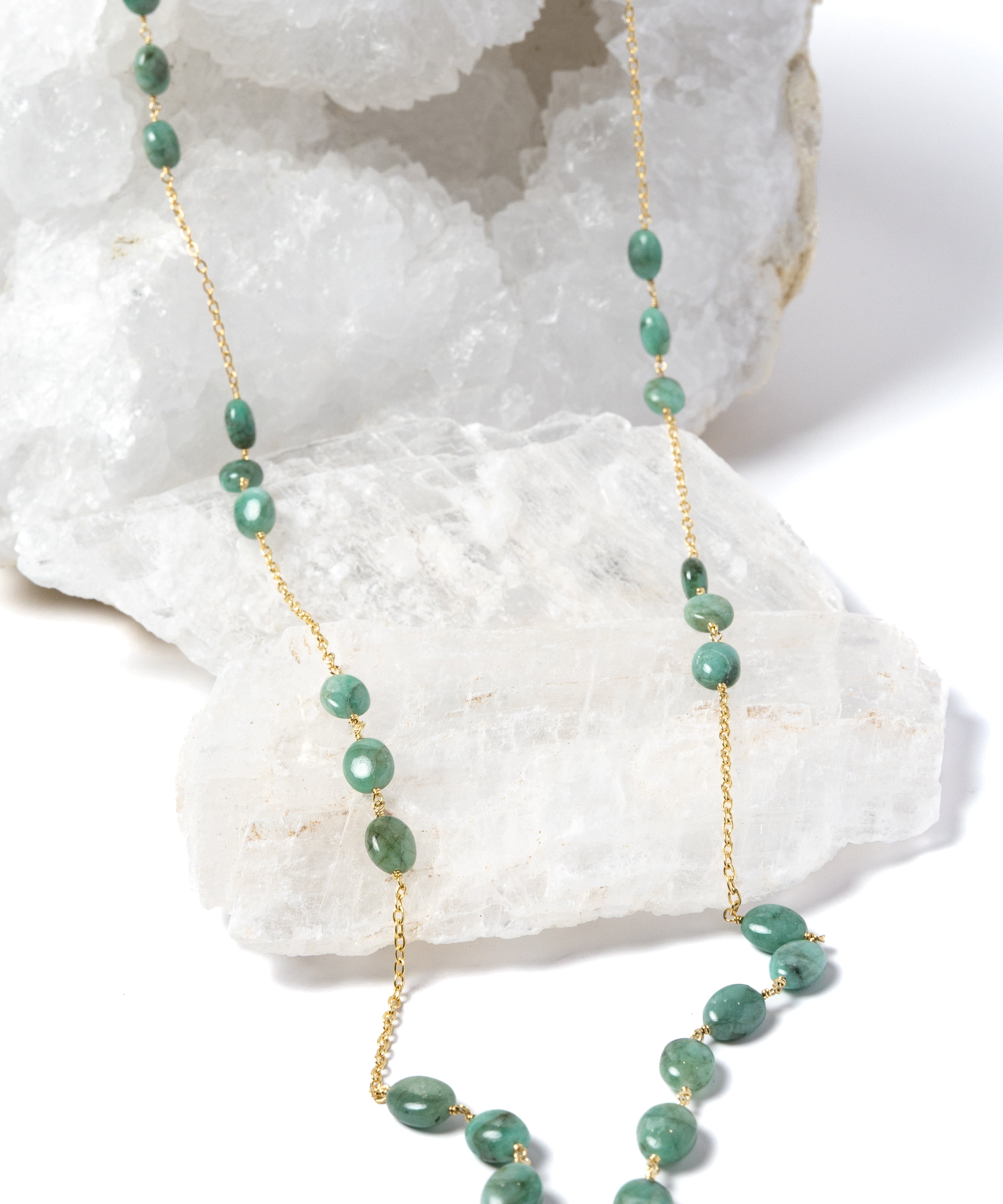 Fortuna Necklace featuring natural emerald gemestones set along a gold-plated chain, a graceful long necklace with a beautifully balanced center composition.