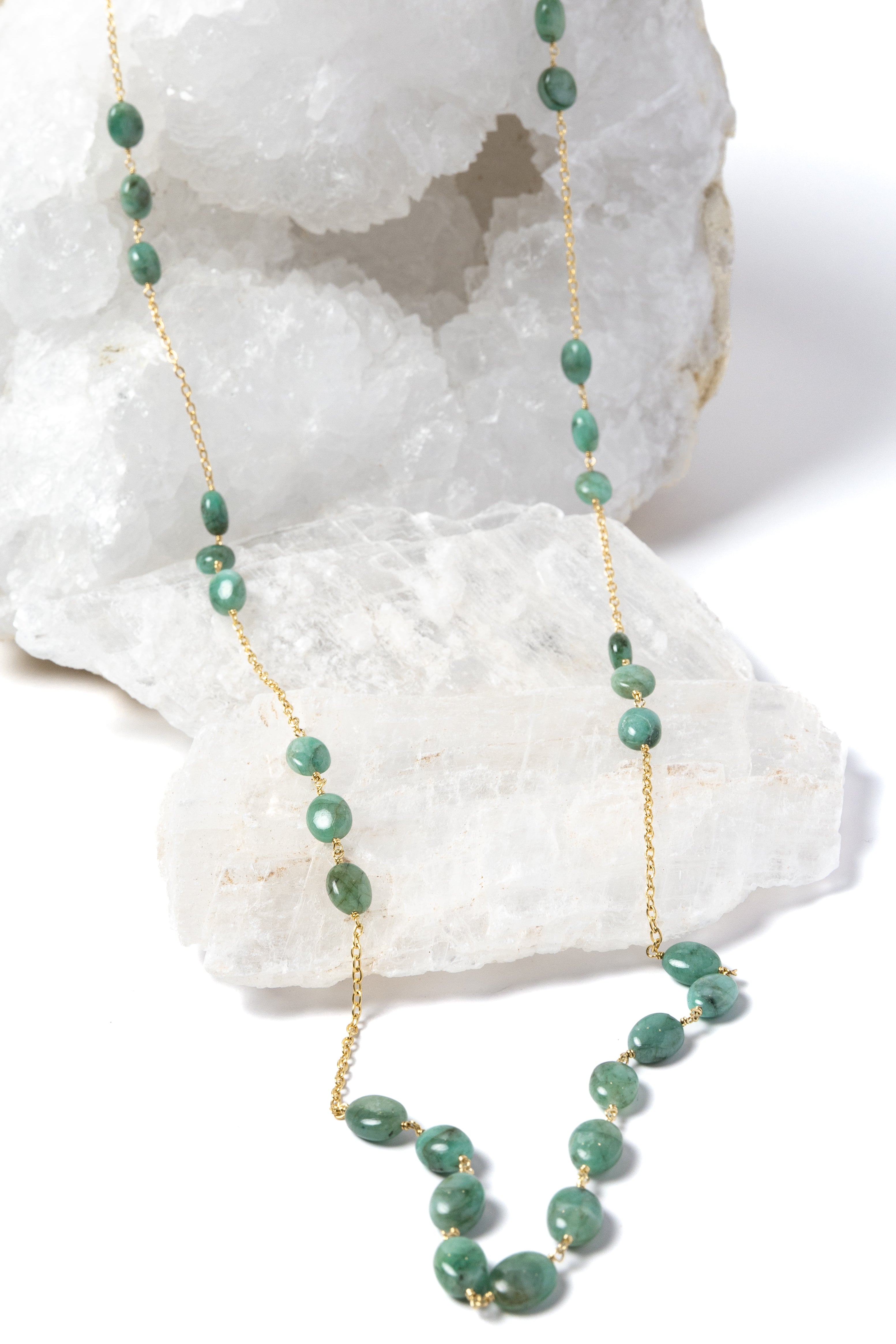 Fortuna Necklace featuring natural emerald gemestones set along a gold-plated chain, a graceful long necklace with a beautifully balanced center composition.