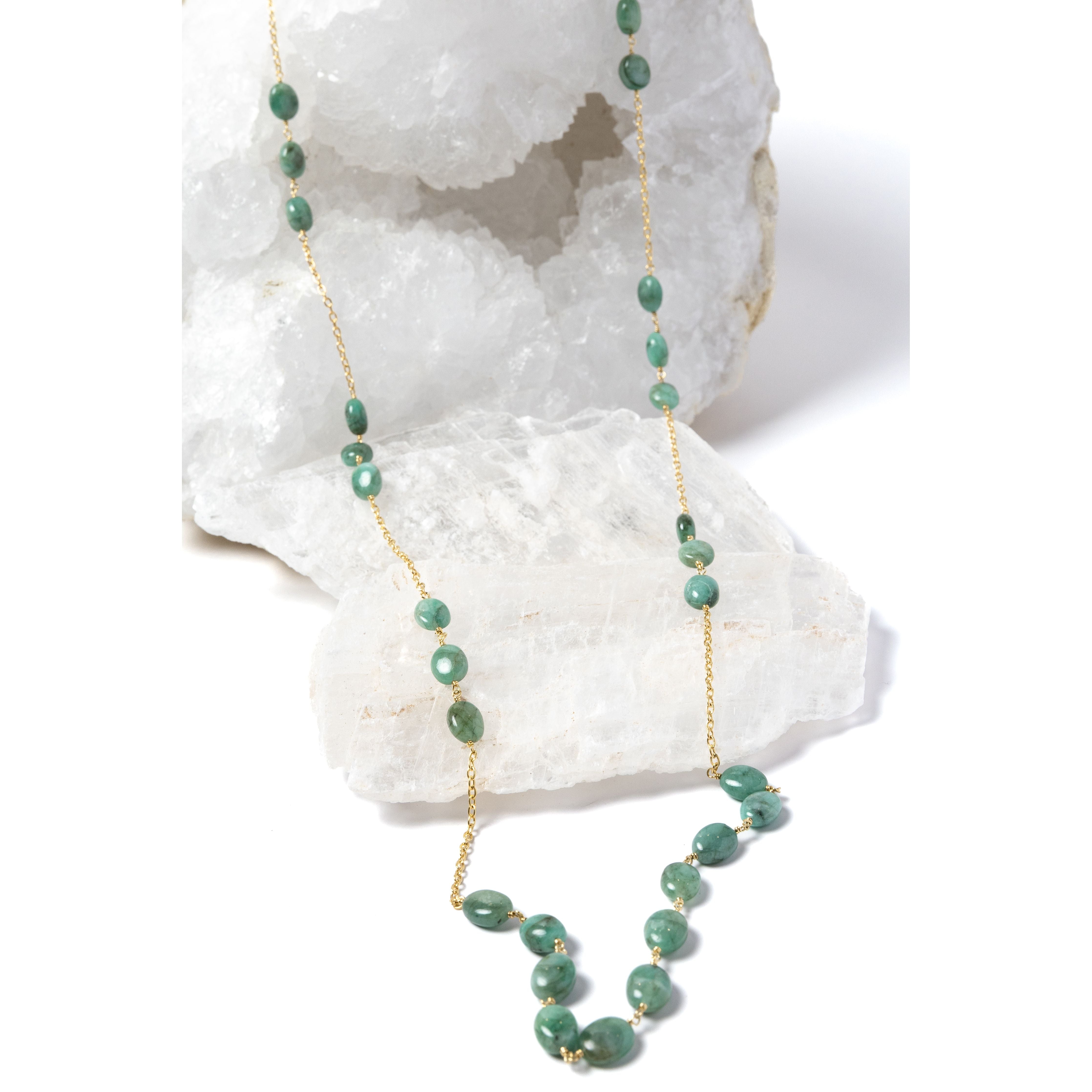 Fortuna Necklace featuring natural emerald gemestones set along a gold-plated chain, a graceful long necklace with a beautifully balanced center composition.