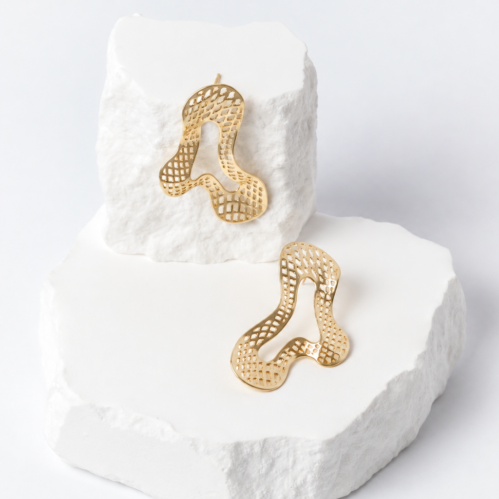 Free Spirit gold-tone earrings with sculptural curved shapes and intricate open-mesh detailing, displayed at different angles to reveal their airy, dimensional design.