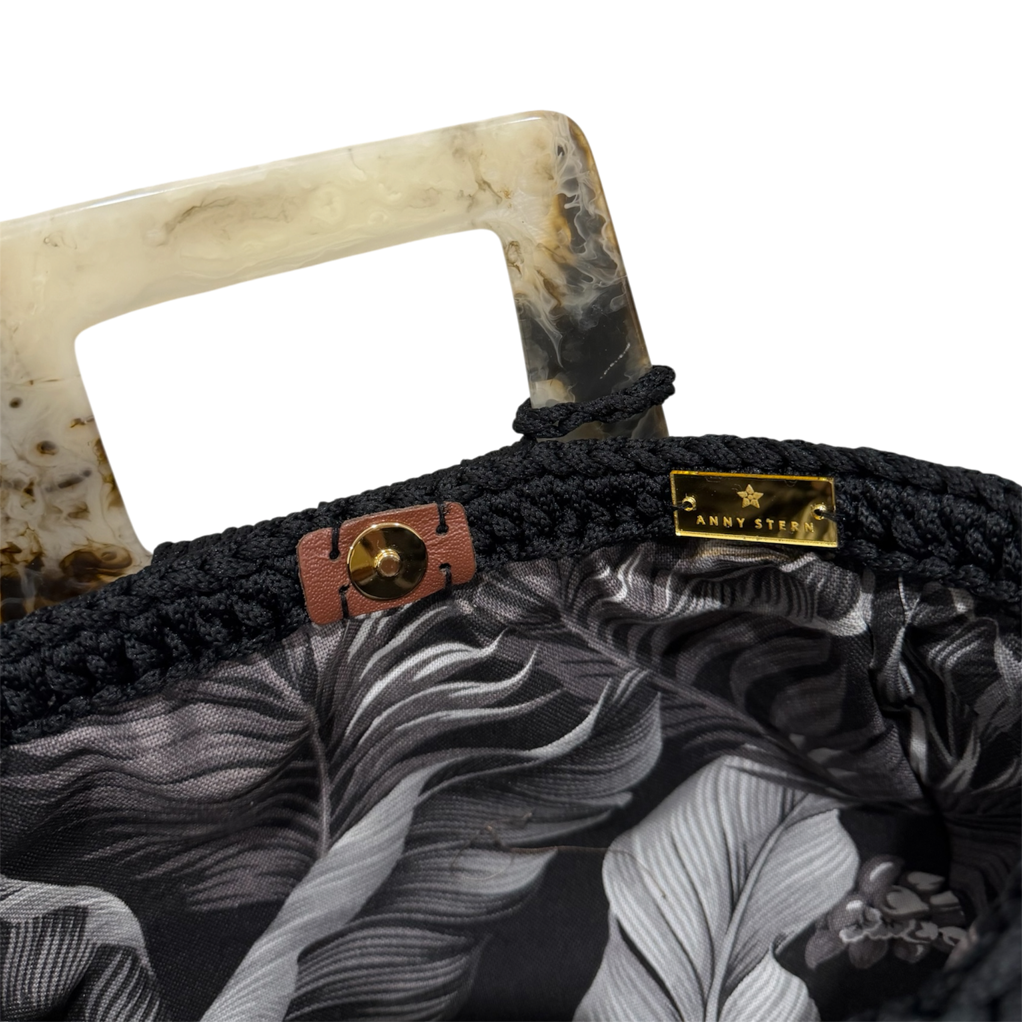 Botanical foliage lining inside the Giselle Bag Black Magnolia in shades of charcoal, ivory, gray, and black