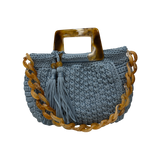 Light blue hand-crocheted Giselle handbag with tortoiseshell resin handle, coordinating chain strap, and tassel detail
