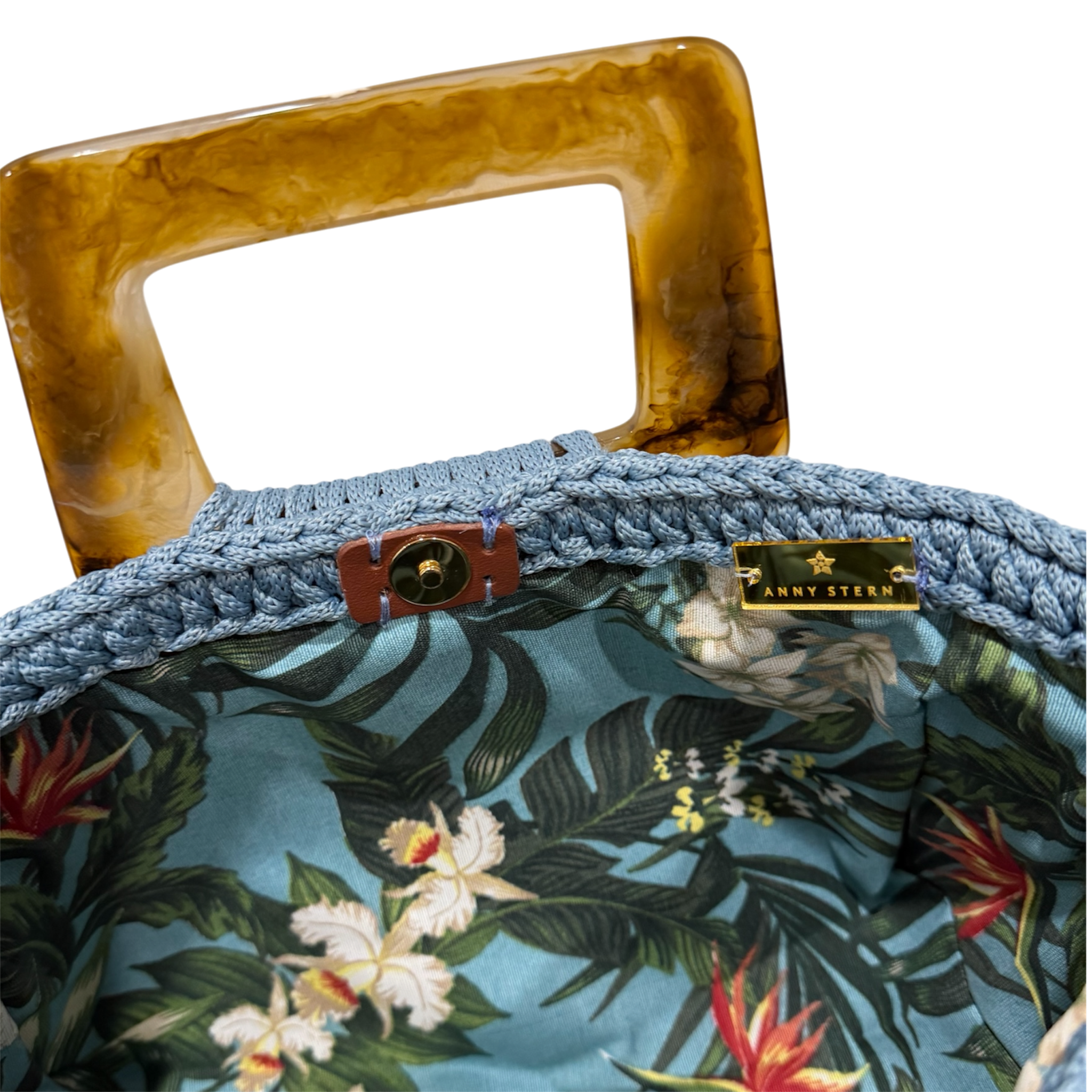 Tropical botanical lining inside the Giselle handbag featuring birds of paradise flowers and lush foliage on a blue background