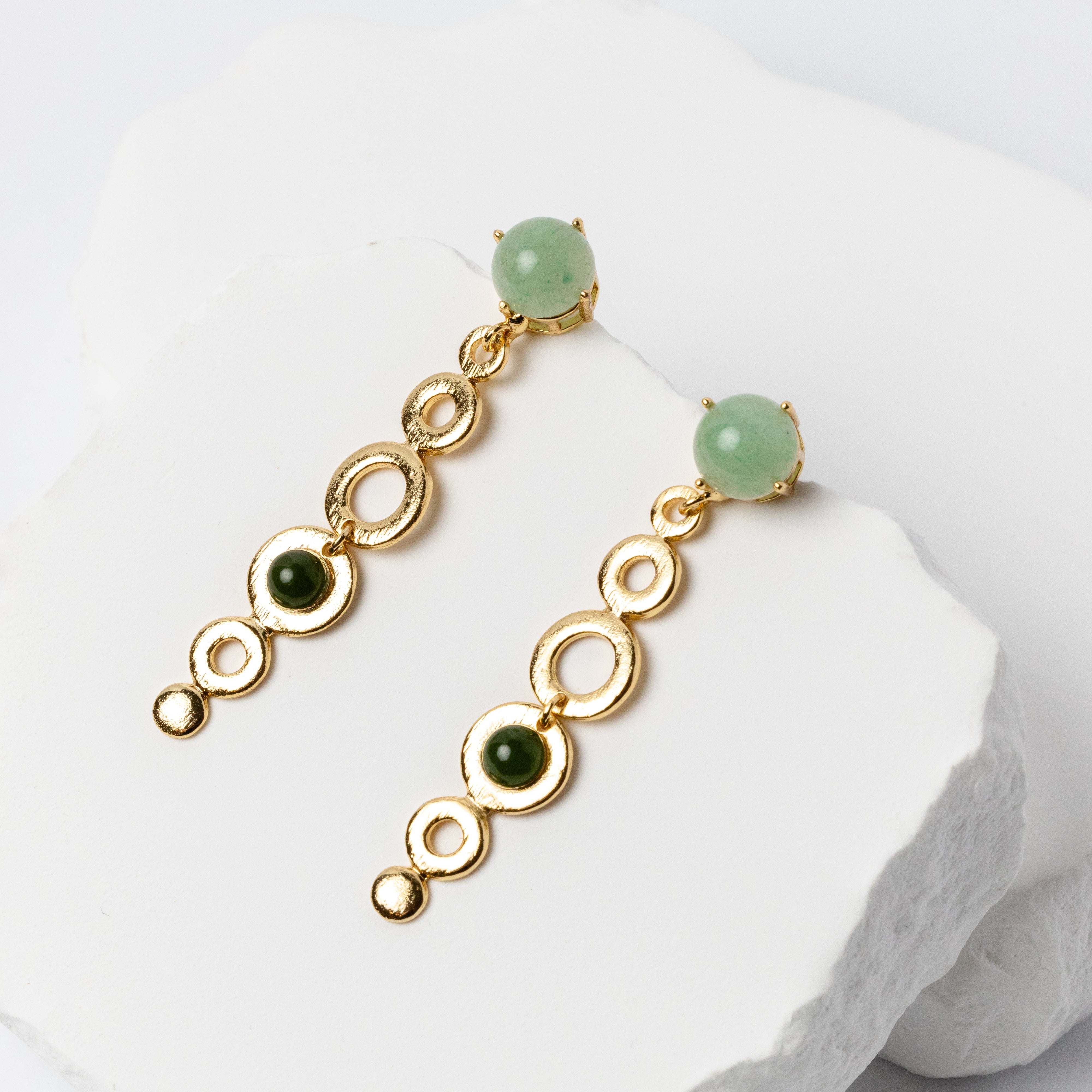 Handcrafted gold-plated dangling earrings featuring 10 mm green aventurine cabochons, 6 mm nephrite jade accents, and delicate graduated open golden circles.
