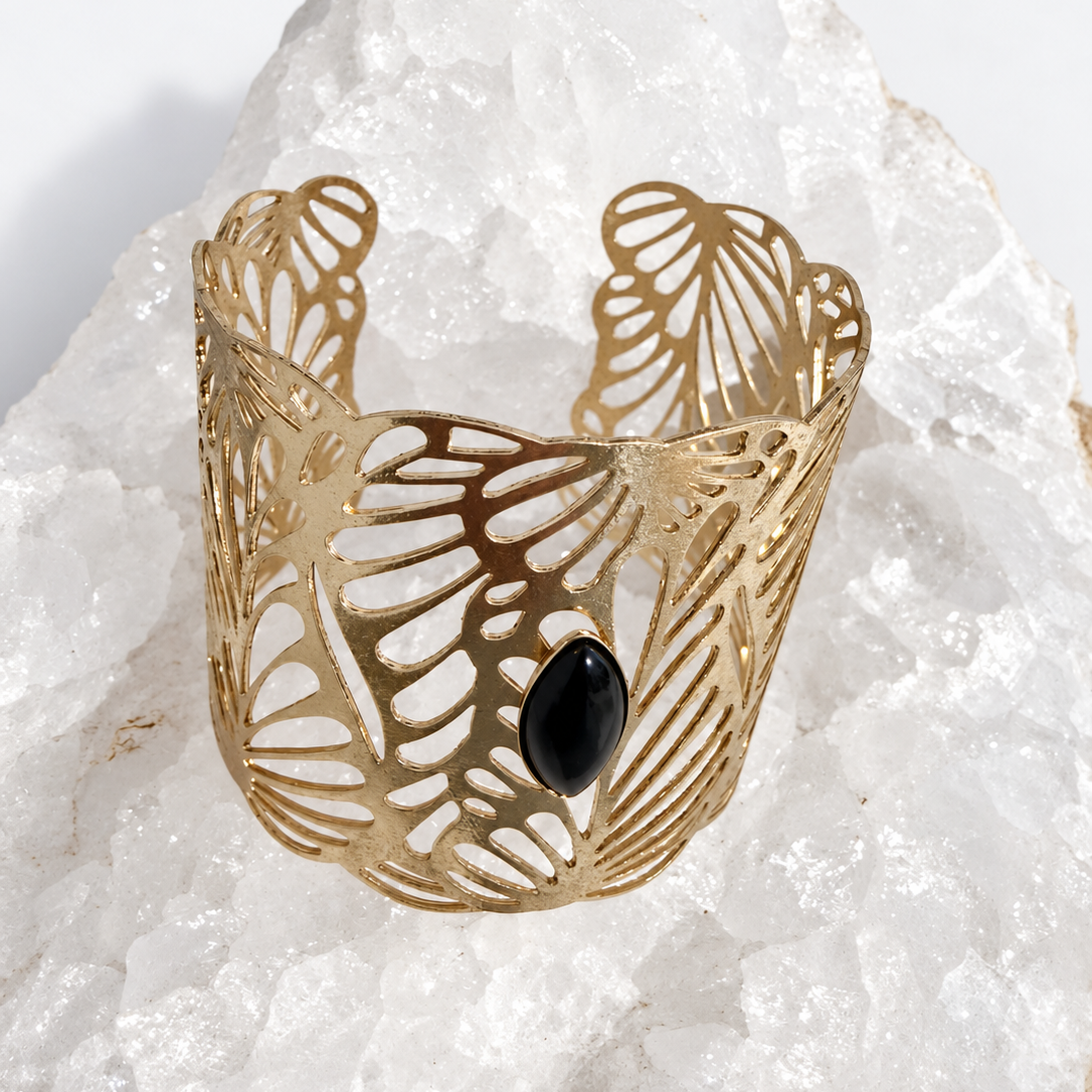 Wide gold-plated Golden Palm cuff bracelet with an intricate lace-like openwork design and a 15 × 7 mm natural black onyx navette cabochon at the center.