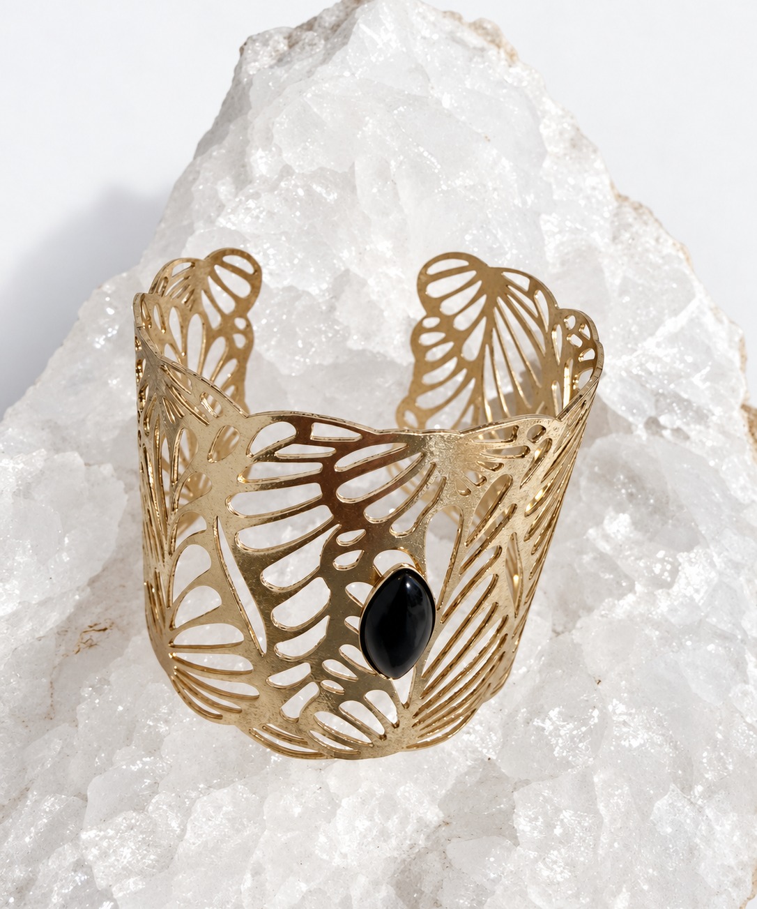 Wide gold-plated Golden Palm cuff bracelet with an intricate lace-like openwork design and a 15 × 7 mm natural black onyx navette cabochon at the center.