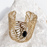 Wide gold-plated Golden Palm cuff bracelet with an intricate lace-like openwork design and a 15 × 7 mm natural black onyx navette cabochon at the center.