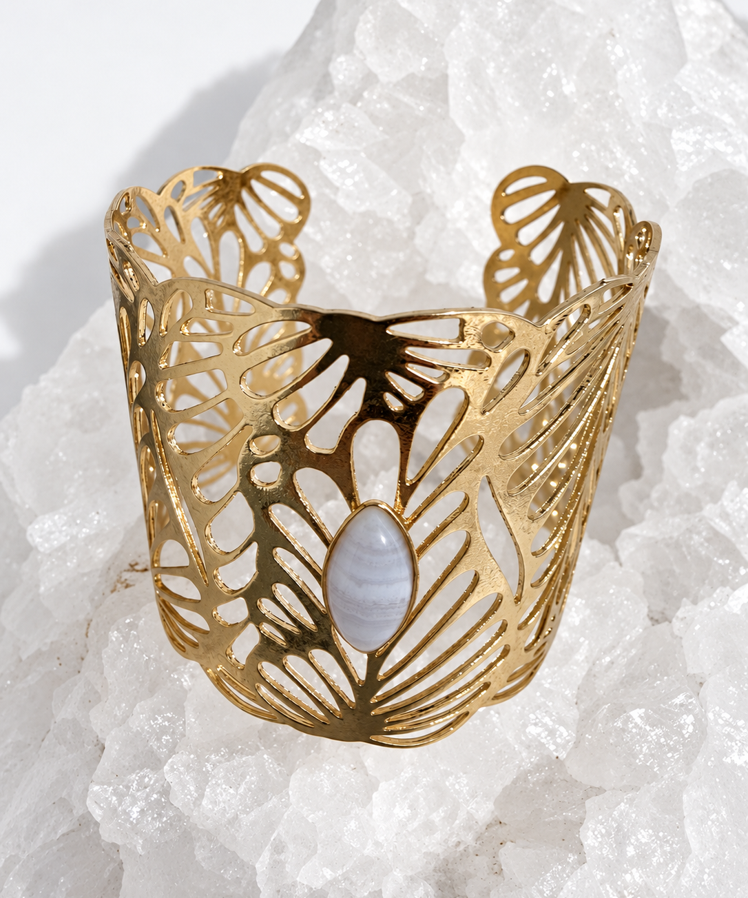 Wide gold-plated Golden Palm cuff bracelet with an intricate lace-like openwork design and a 15 × 7 mm natural blue lace agate navette cabochon at the center.