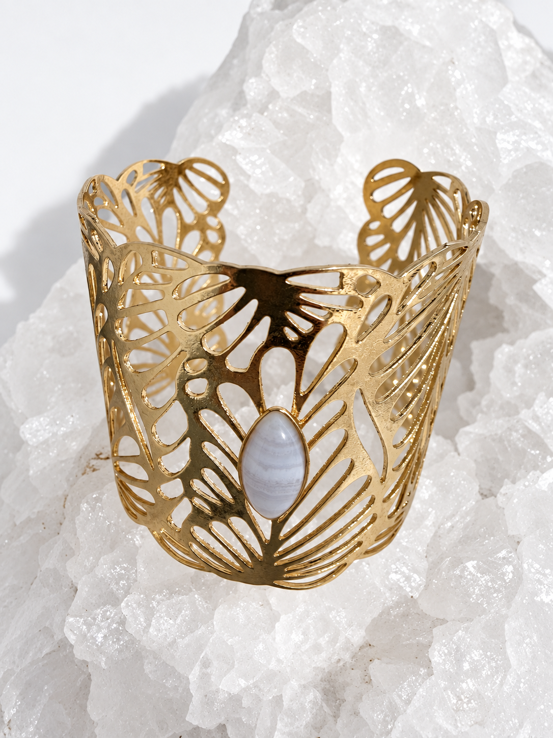 Wide gold-plated Golden Palm cuff bracelet with an intricate lace-like openwork design and a 15 × 7 mm natural blue lace agate navette cabochon at the center.