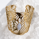 Wide gold-plated Golden Palm cuff bracelet with an intricate lace-like openwork design and a 15 × 7 mm natural blue lace agate navette cabochon at the center.
