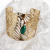 Wide gold-plated Golden Palm cuff bracelet with an intricate lace-like openwork design and a 15 × 7 mm natural malachite navette cabochon at the center.