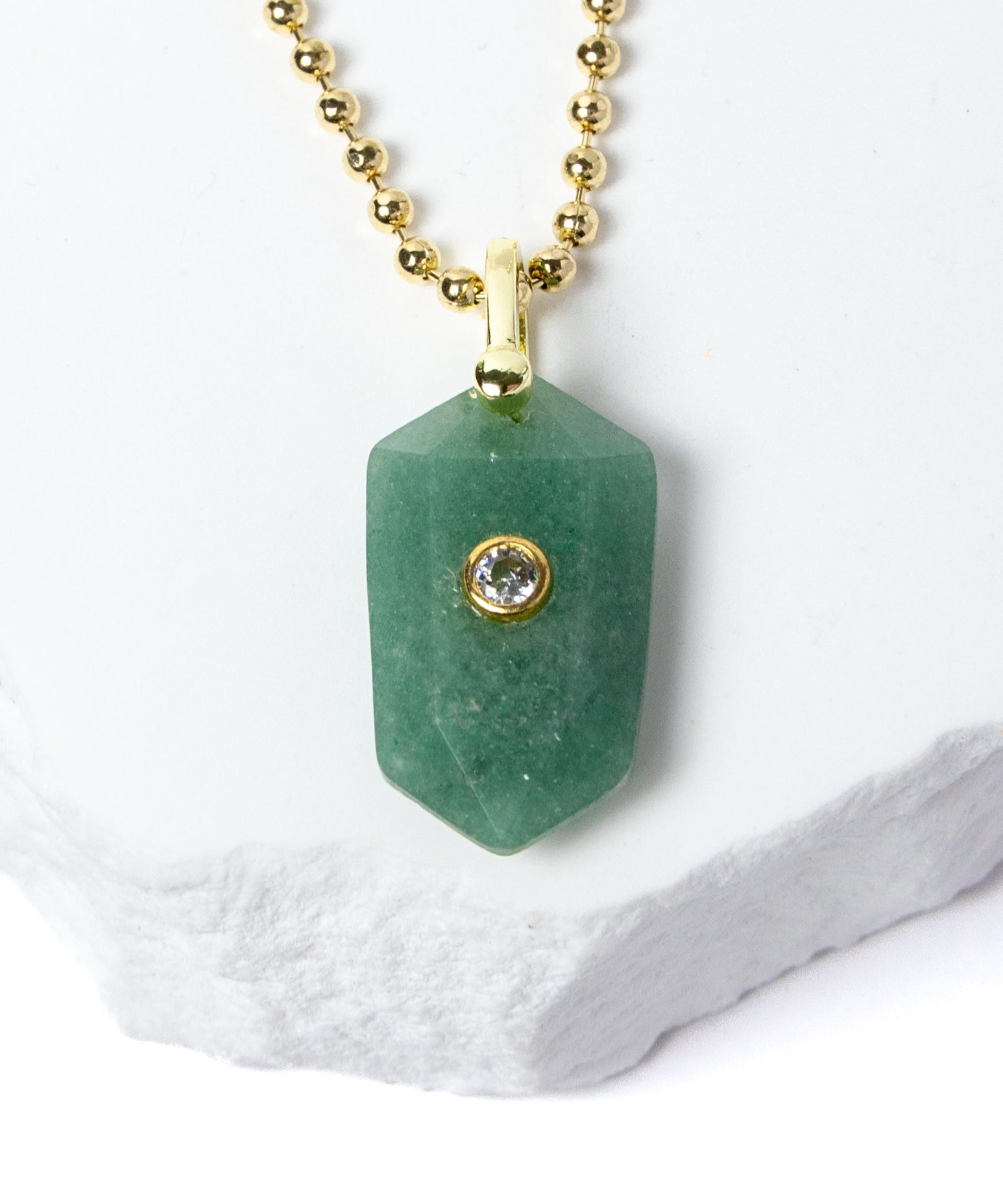 Close-up of a faceted Green Aventurine pendant showcasing its soft botanical green color, natural stone character, cubic zirconia accent, and gold-plated setting.