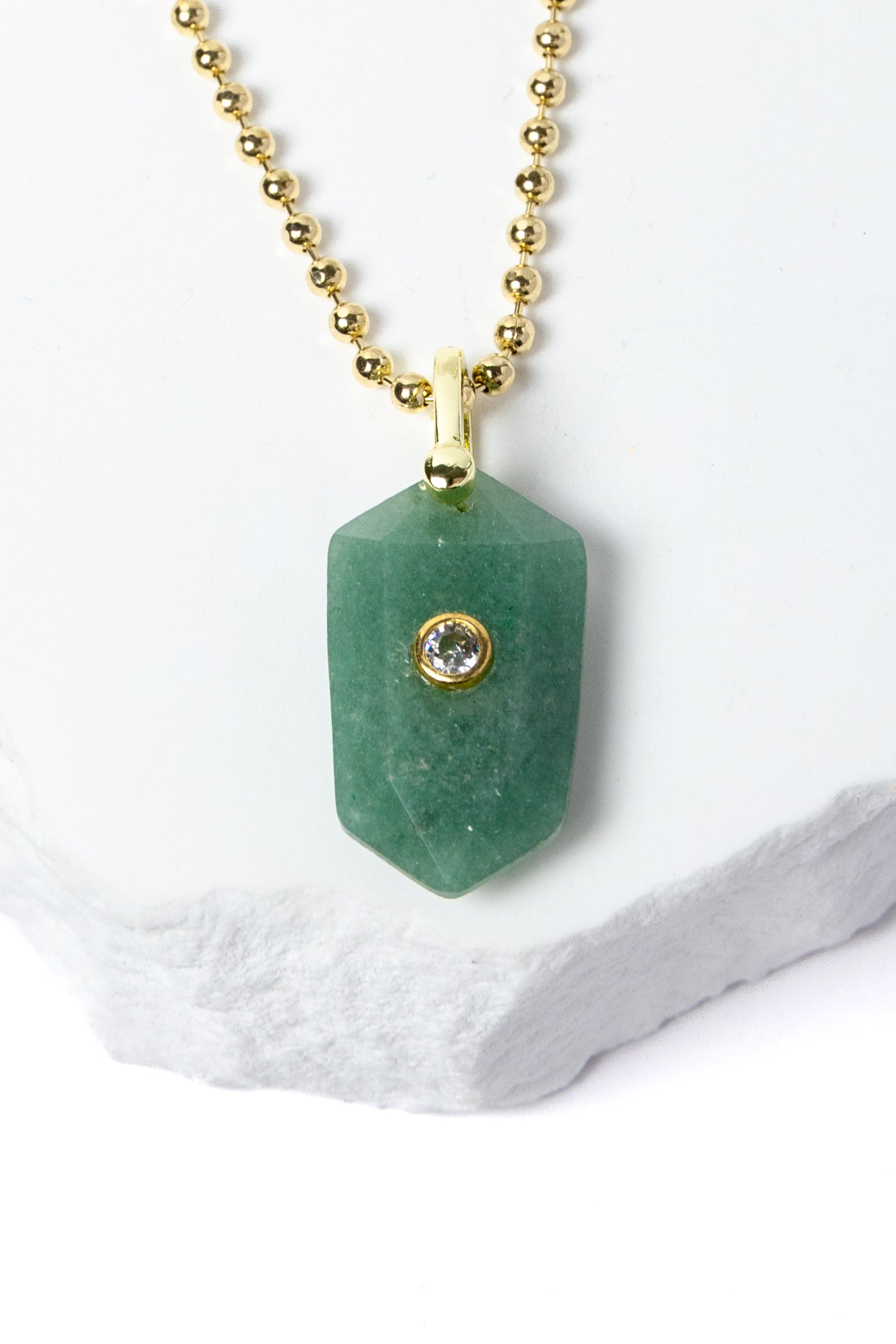 Close-up of a faceted Green Aventurine pendant showcasing its soft botanical green color, natural stone character, cubic zirconia accent, and gold-plated setting.