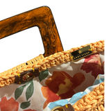 Hand-crocheted luxury handbag interior with soft floral lining and spacious open design, featuring refined crochet texture, sculptural resin handle and elegant tassel with chain detail