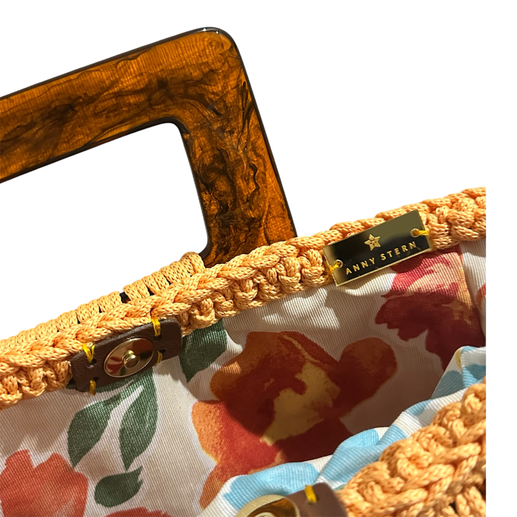 Hand-crocheted luxury handbag interior with soft floral lining and spacious open design, featuring refined crochet texture, sculptural resin handle and elegant tassel with chain detail