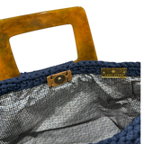 Interior view of the Giselle handbag · Midnight Indigo, showing a patterned lining, framed by the structured crochet body and finished with refined resin handle details.