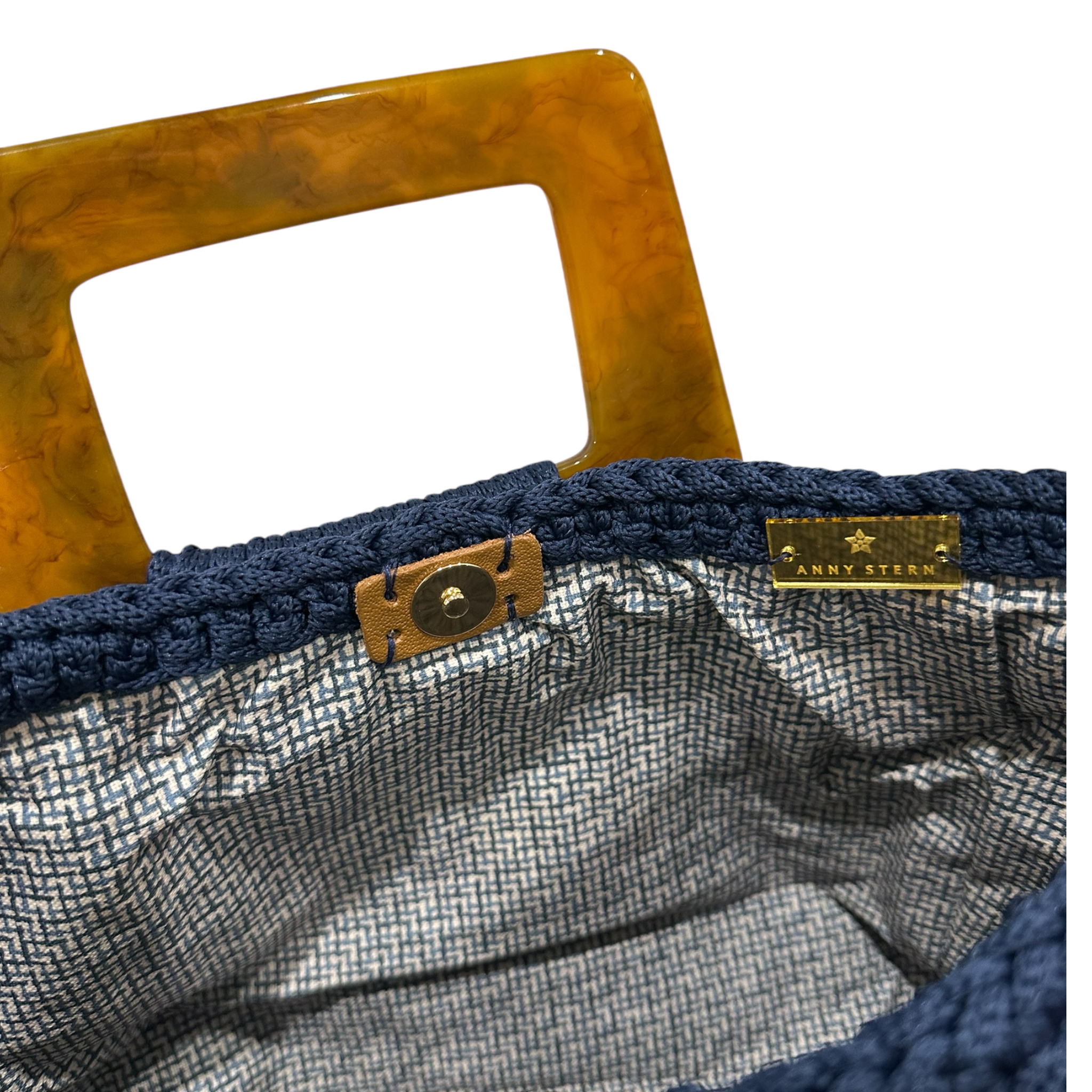 Interior view of the Giselle handbag · Midnight Indigo, showing a patterned lining, framed by the structured crochet body and finished with refined resin handle details.