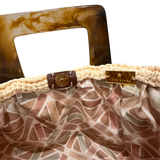 Interior view of the Paloma handbag · Lumen Dune, featuring a geometric mosaic lining in soft neutral tones, framed by the textured crochet structure and refined resin handle details.