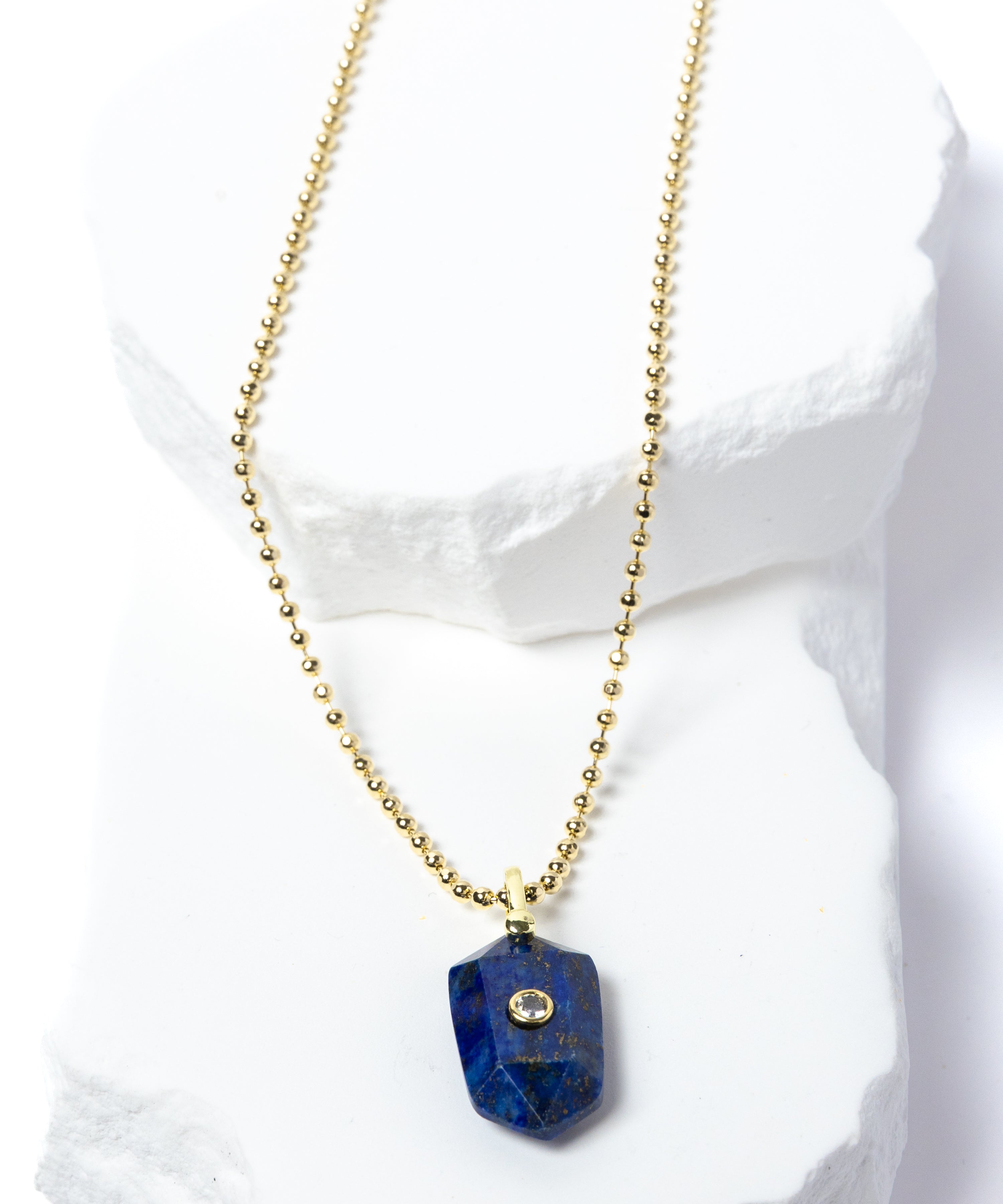 Natural Lapis Lazuli Gem Charm Necklace featuring a faceted royal-blue gemstone pendant with natural golden inclusions, cubic zirconia accent, and gold-plated beaded chain 