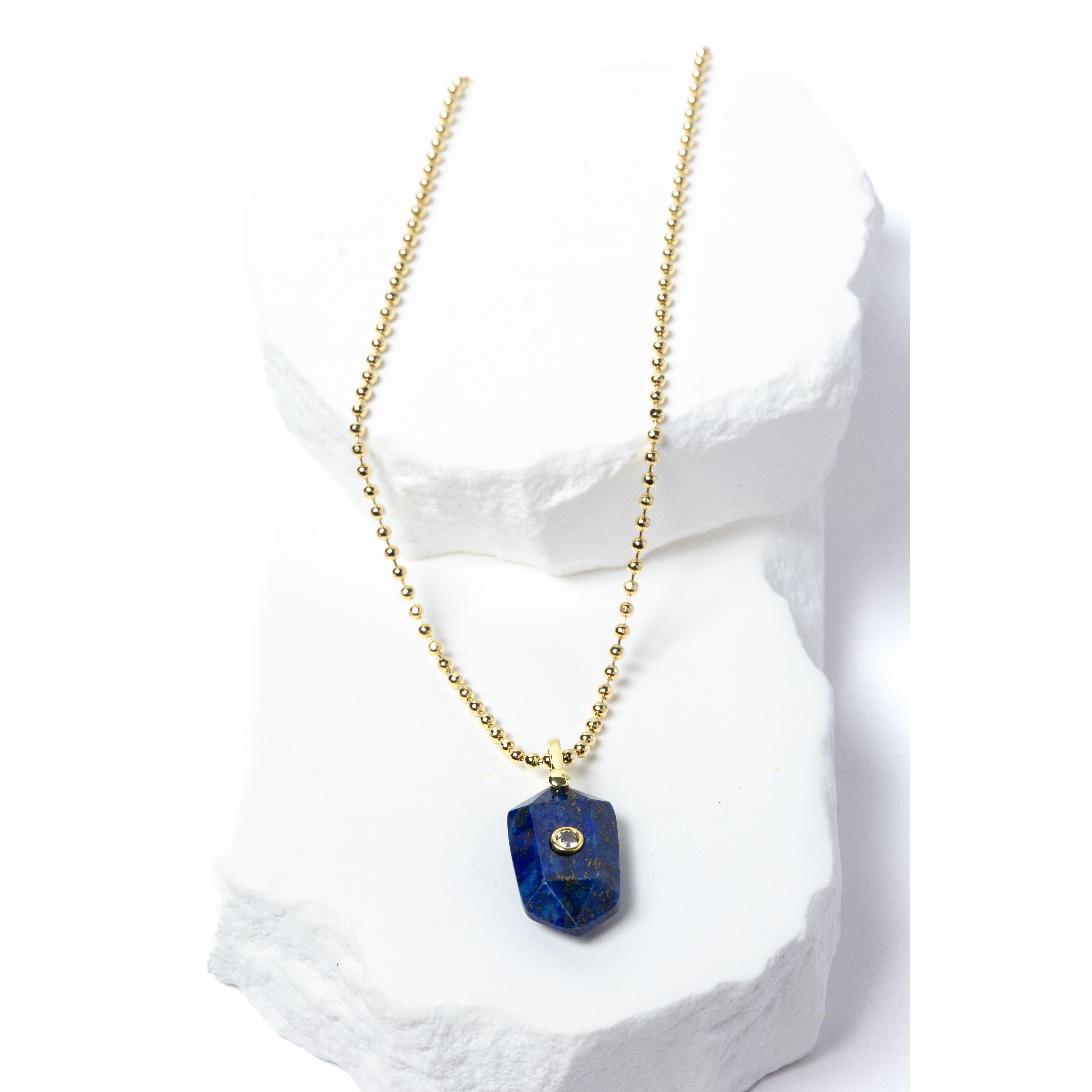 Natural Lapis Lazuli Gem Charm Necklace featuring a faceted royal-blue gemstone pendant with natural golden inclusions, cubic zirconia accent, and gold-plated beaded chain 