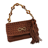 Handcrafted Polly Clutch in deep cinnamon-brown with warm copper undertones, detailed crochet texture, sculptural amber-inspired resin chain strap, polished gold-tone front accent, and hand-finished tassel detail designed for elevated day-to-evening styling.