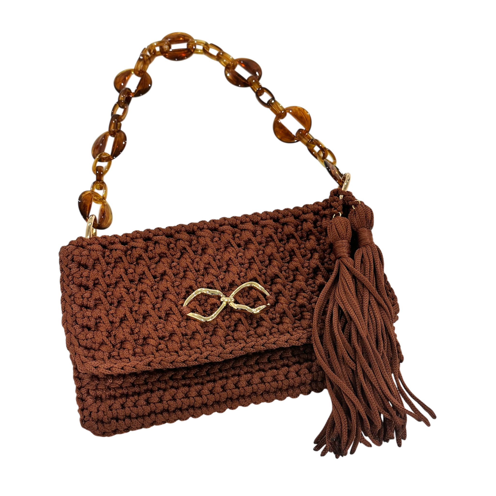 Handcrafted Polly Clutch in deep cinnamon-brown with warm copper undertones, detailed crochet texture, sculptural amber-inspired resin chain strap, polished gold-tone front accent, and hand-finished tassel detail designed for elevated day-to-evening styling.