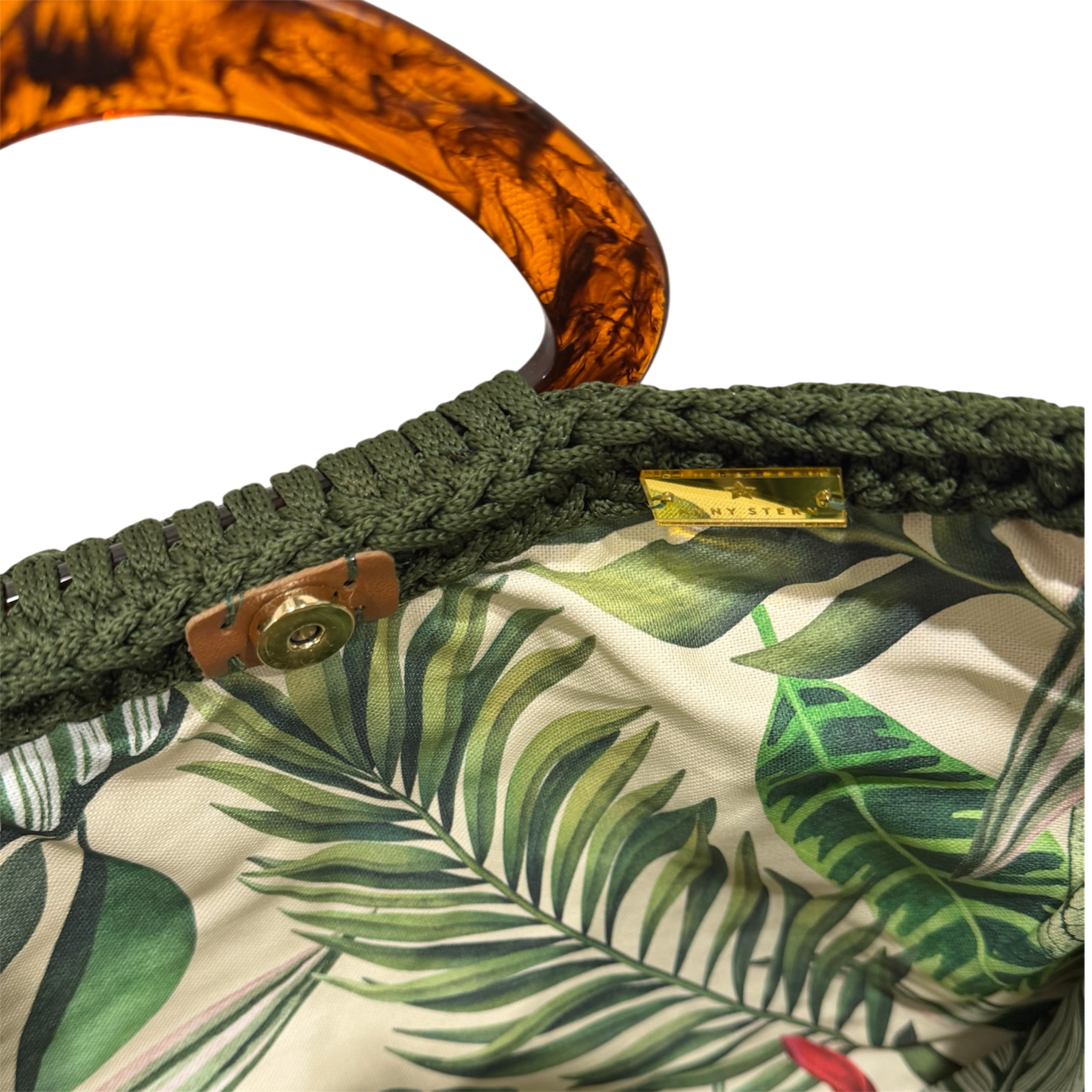 Interior of the Monique handbag in deep olive green featuring a palm-inspired botanical lining and magnetic snap closure.