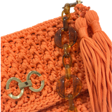 Close-up of crochet texture, gold-tone detail, and tassel on orange Polly clutch