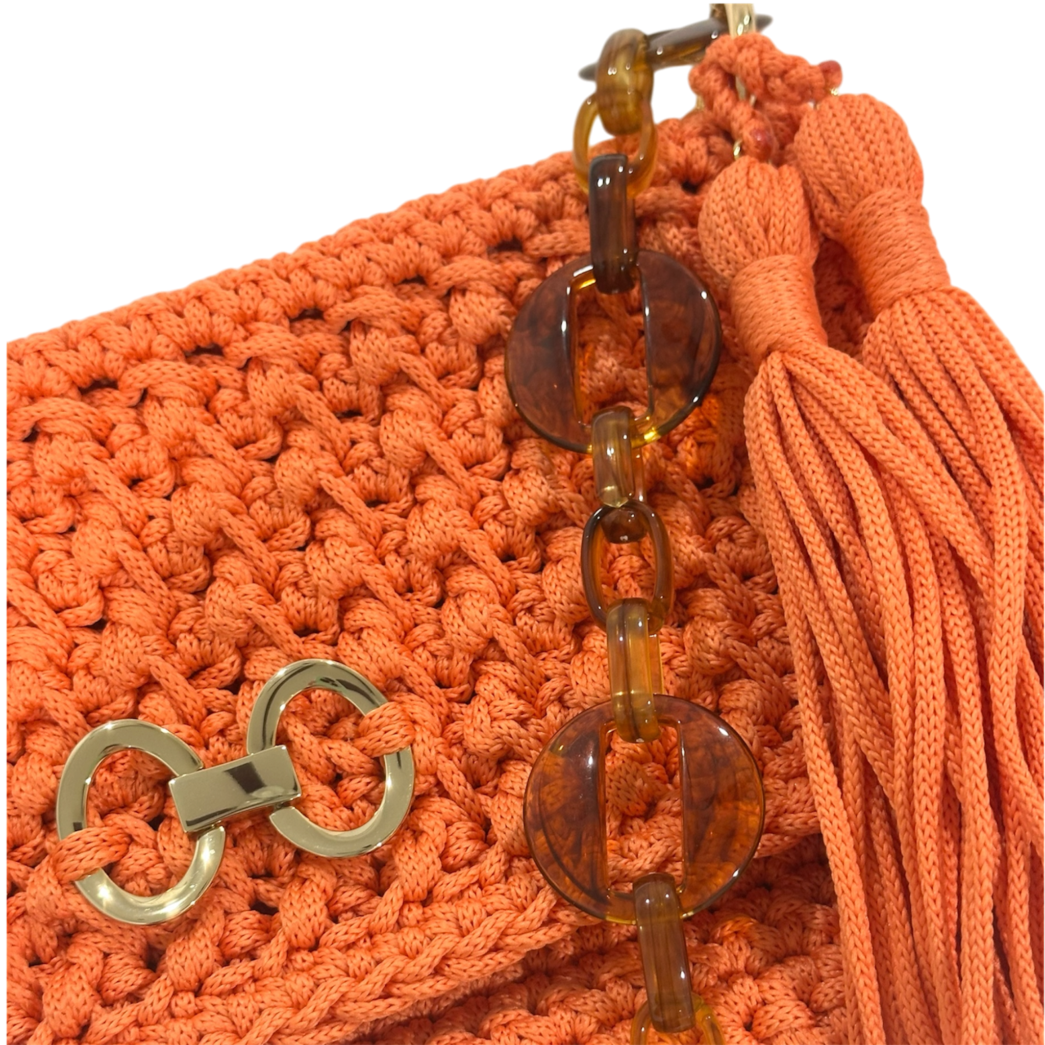 Close-up of crochet texture, gold-tone detail, and tassel on orange Polly clutch