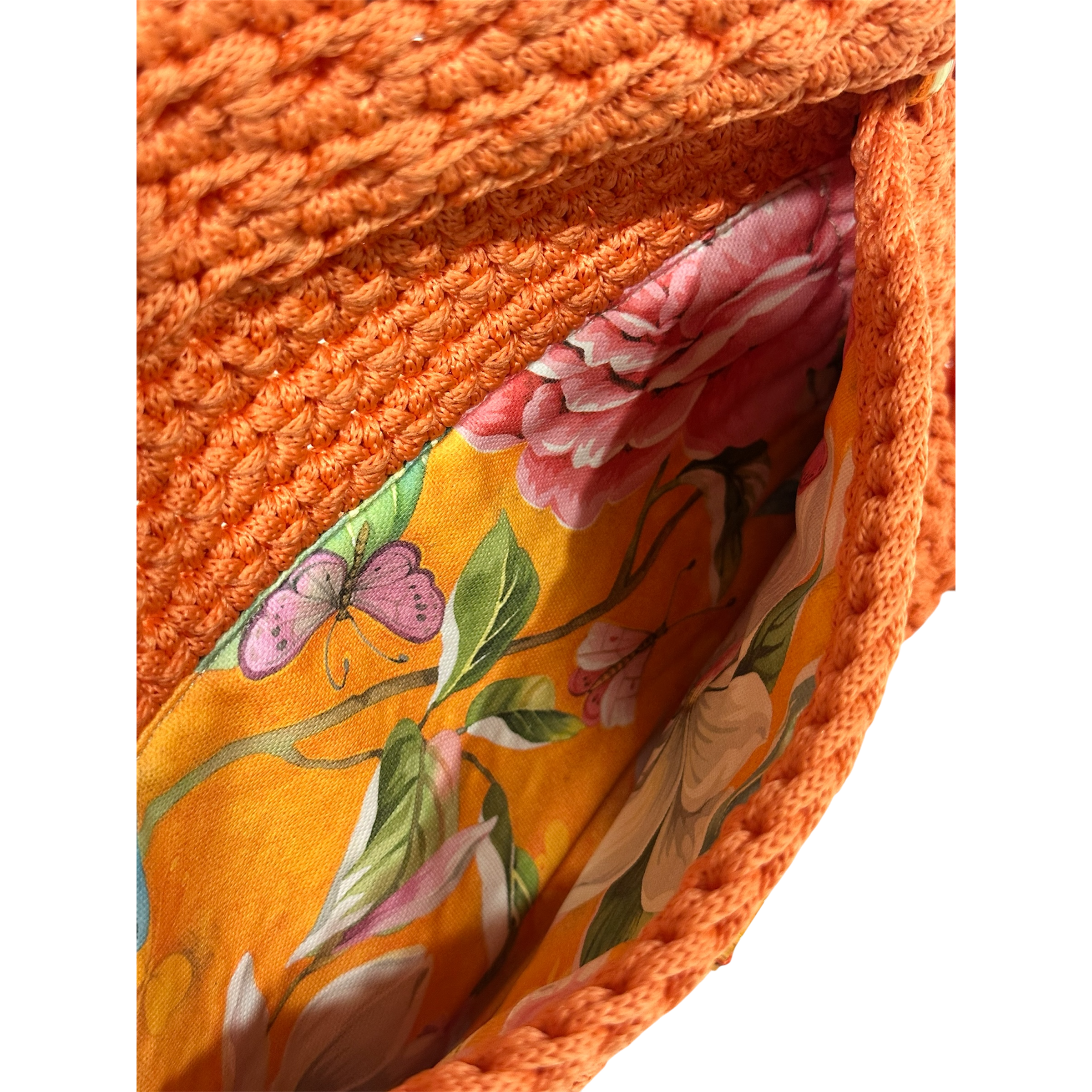 Interior of orange crochet clutch with floral lining and secure closure
