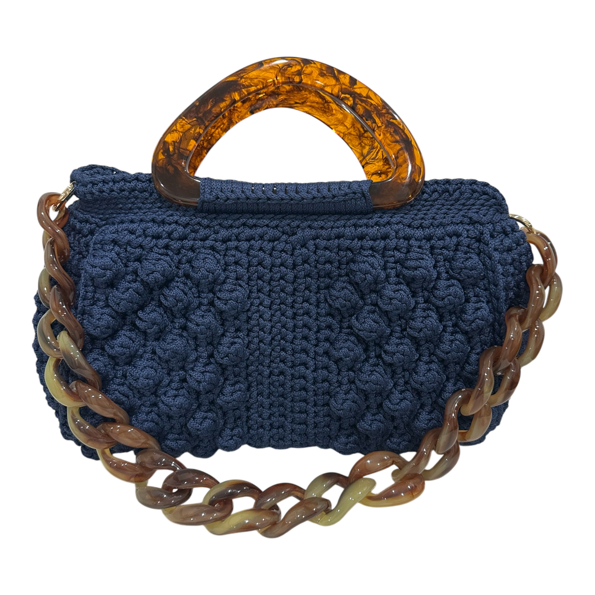 Hand-crocheted Paloma handbag in a deep indigo-blue tone with dimensional textured stitching, featuring a sculptural resin top handle and a coordinating chain strap.