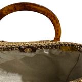 Hand-crocheted luxury handbag interior with refined neutral lining and spacious open design, featuring intricate crochet texture, sculptural resin handle and flowing tassel with chain detail