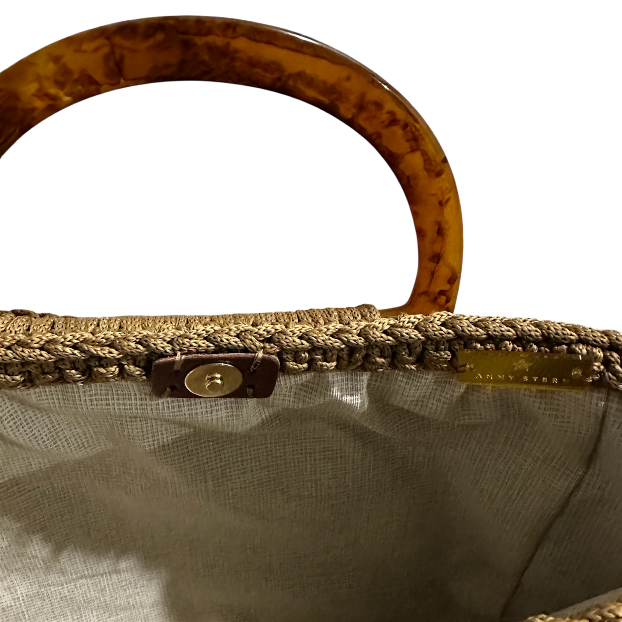 Hand-crocheted luxury handbag interior with refined neutral lining and spacious open design, featuring intricate crochet texture, sculptural resin handle and flowing tassel with chain detail