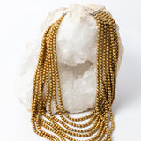 Pearl Opulence Necklace featuring eight cascading strands of natural honey-gold freshwater potato pearls, approximately 6–7 mm, with subtle green undertones and graduated lengths from 18 to 47 inches, plus a 2-inch extension.
