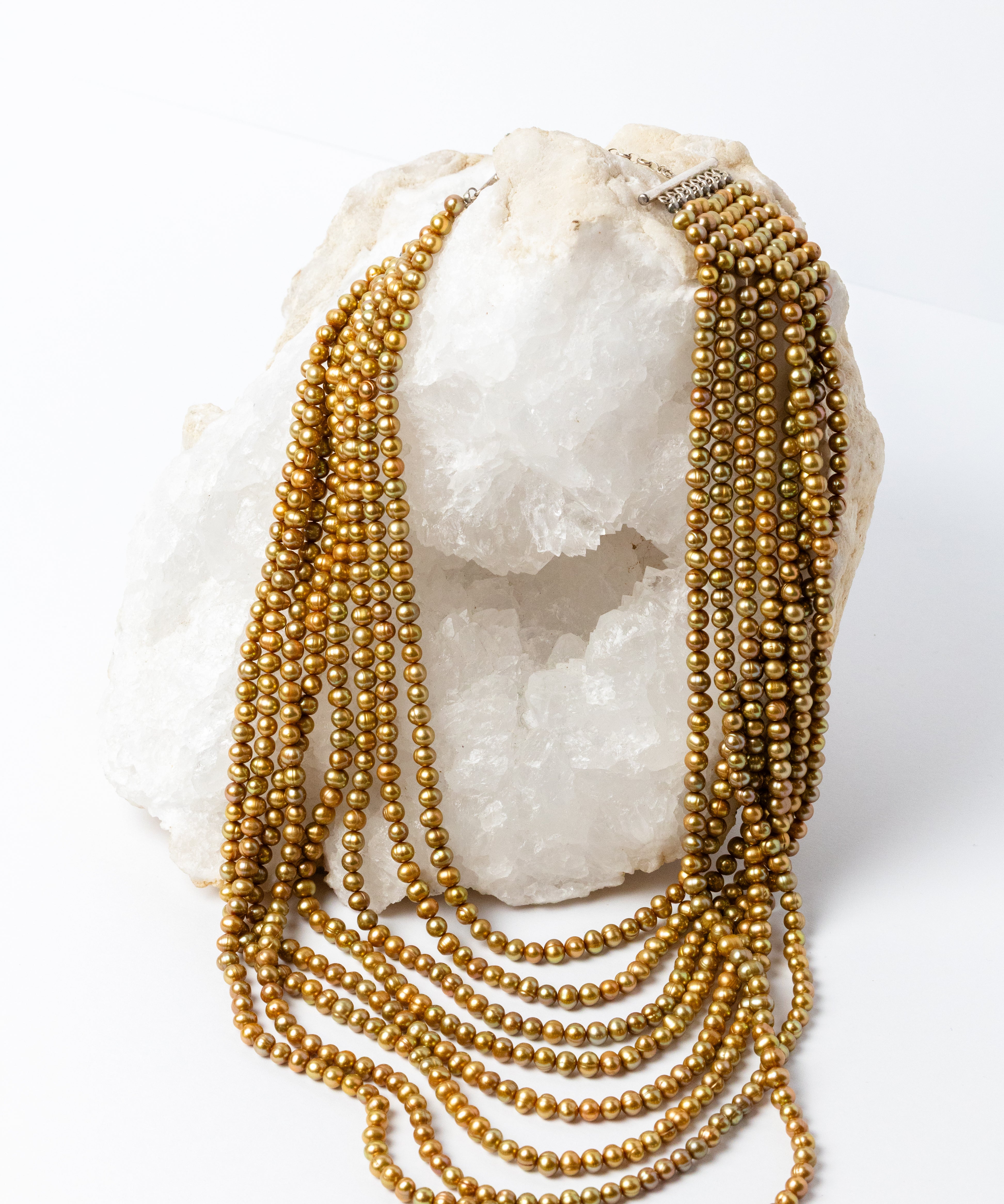 Pearl Opulence Necklace featuring eight cascading strands of natural honey-gold freshwater potato pearls, approximately 6–7 mm, with subtle green undertones and graduated lengths from 18 to 47 inches, plus a 2-inch extension.