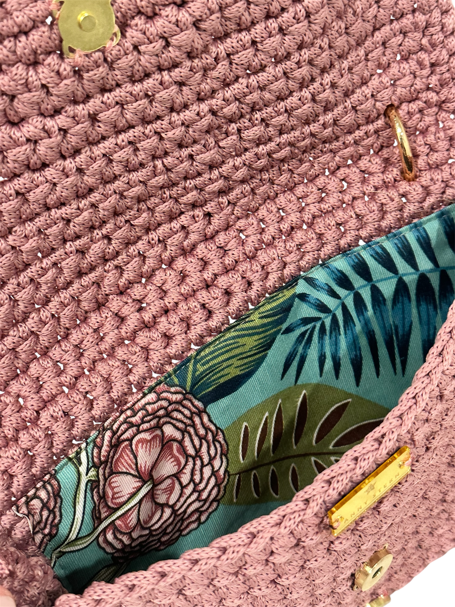 Interior of Camille Clutch with vibrant botanical floral lining in pink, green, and blue tones and secure closure