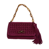 Magenta hand-crocheted Polly Clutch Mulberry Reserve featuring a resin chain strap, bronze hardware, decorative front accent, tassel detail, and textured crochet finish