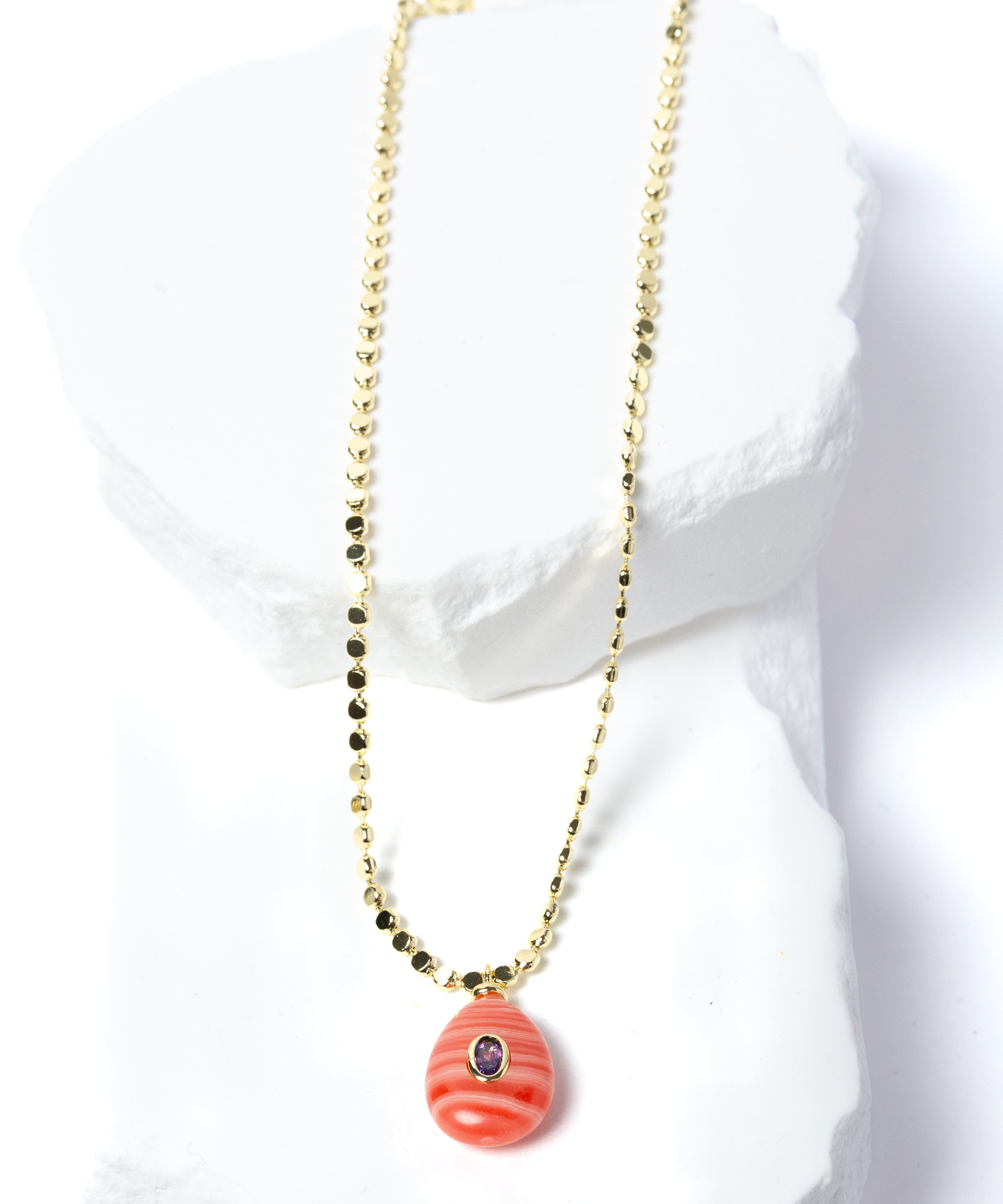 Gem Charm Necklace featuring a genuine rhodochrosite pendant with natural coral-pink banding, cubic zirconia accent, and gold-plated beaded chain.