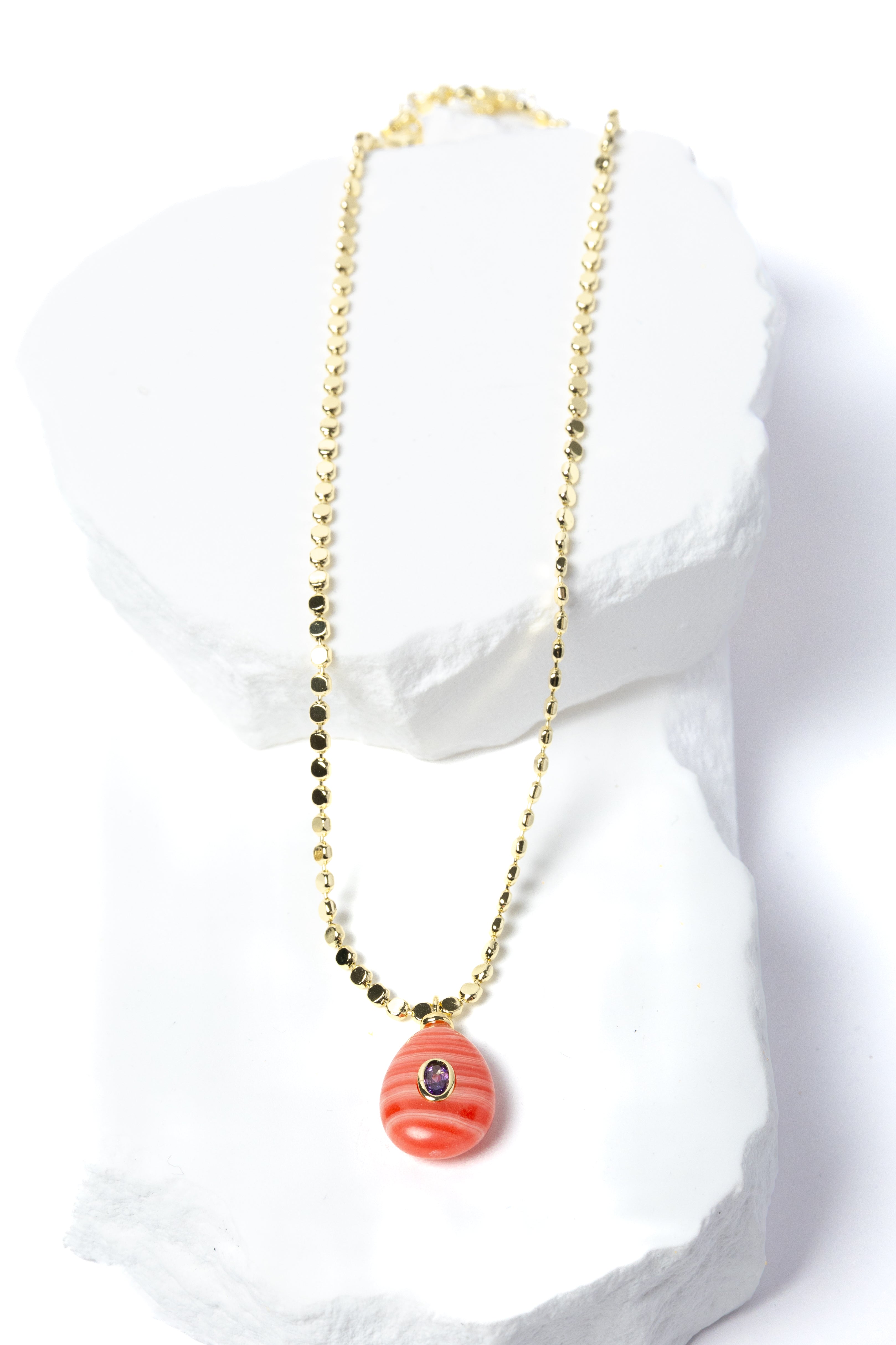 Gem Charm Necklace featuring a genuine rhodochrosite pendant with natural coral-pink banding, cubic zirconia accent, and gold-plated beaded chain.