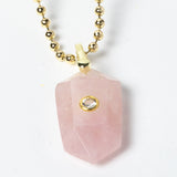 Close-up of a natural Rose Quartz pendant showcasing soft blush-pink tones, faceted geometric shape, cubic zirconia detail, and gold-plated setting.