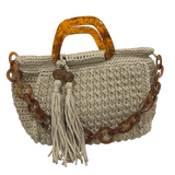 Hand-crocheted Giselle handbag in a warm beige-earth tone with dimensional textured stitching, featuring sculptural amber-marbled resin round handles, a coordinating resin chain strap, and two silky tassels finished with polished resin bead accents.  