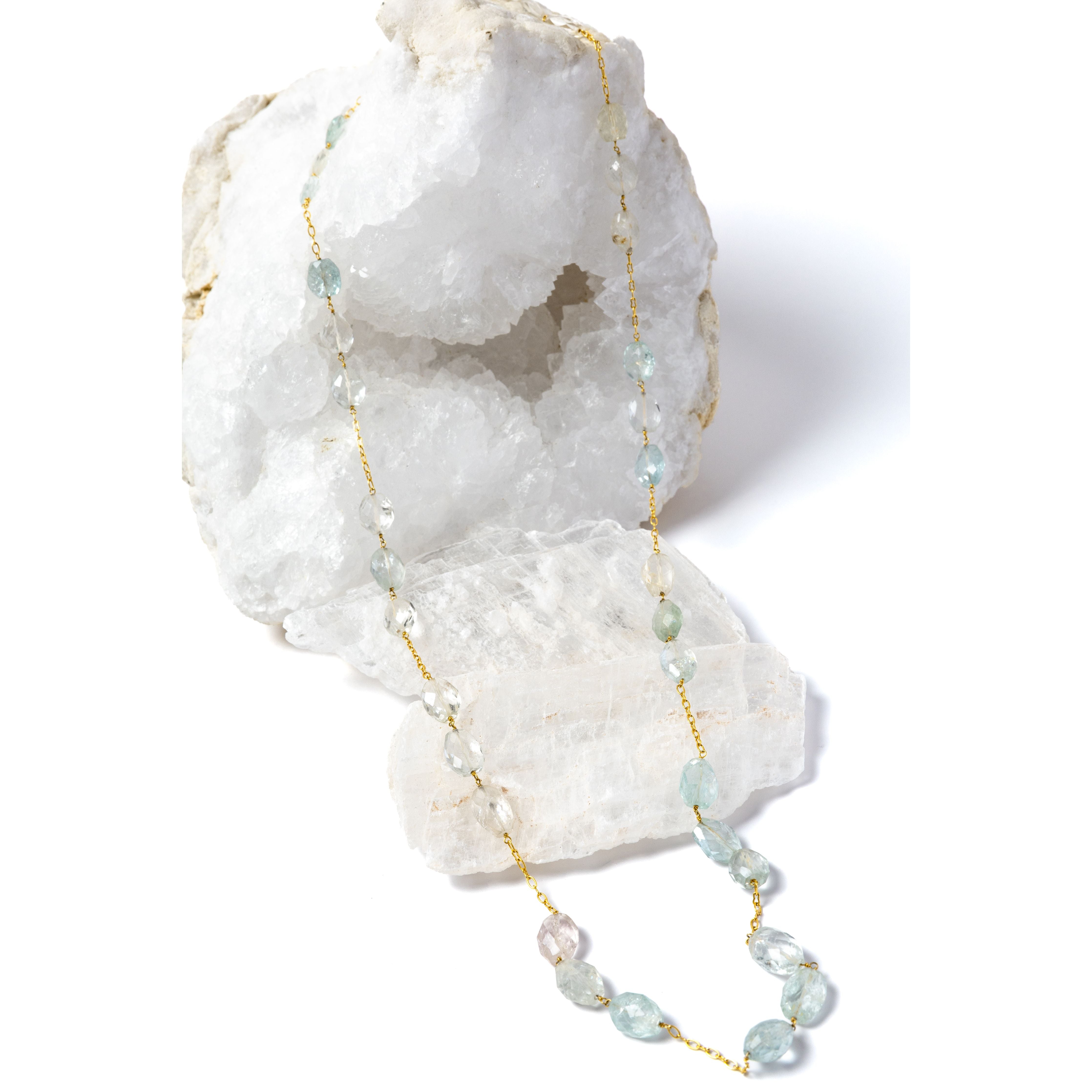 Serenity Mist long necklace featuring approximately 127 carats of natural faceted aquamarine gemstones set along a gold-plated chain in a graceful, fluid design.