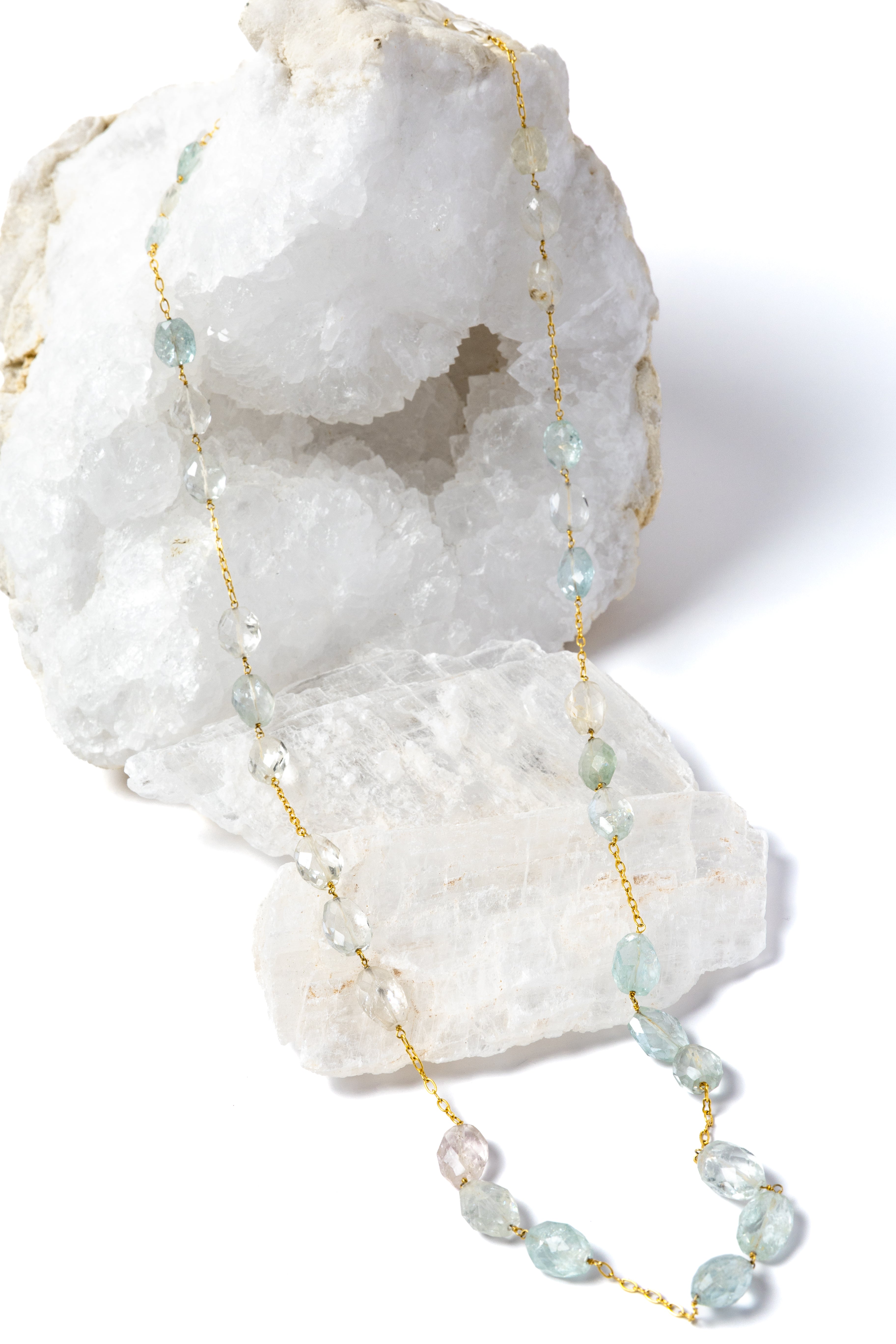 Serenity Mist long necklace featuring approximately 127 carats of natural faceted aquamarine gemstones set along a gold-plated chain in a graceful, fluid design.