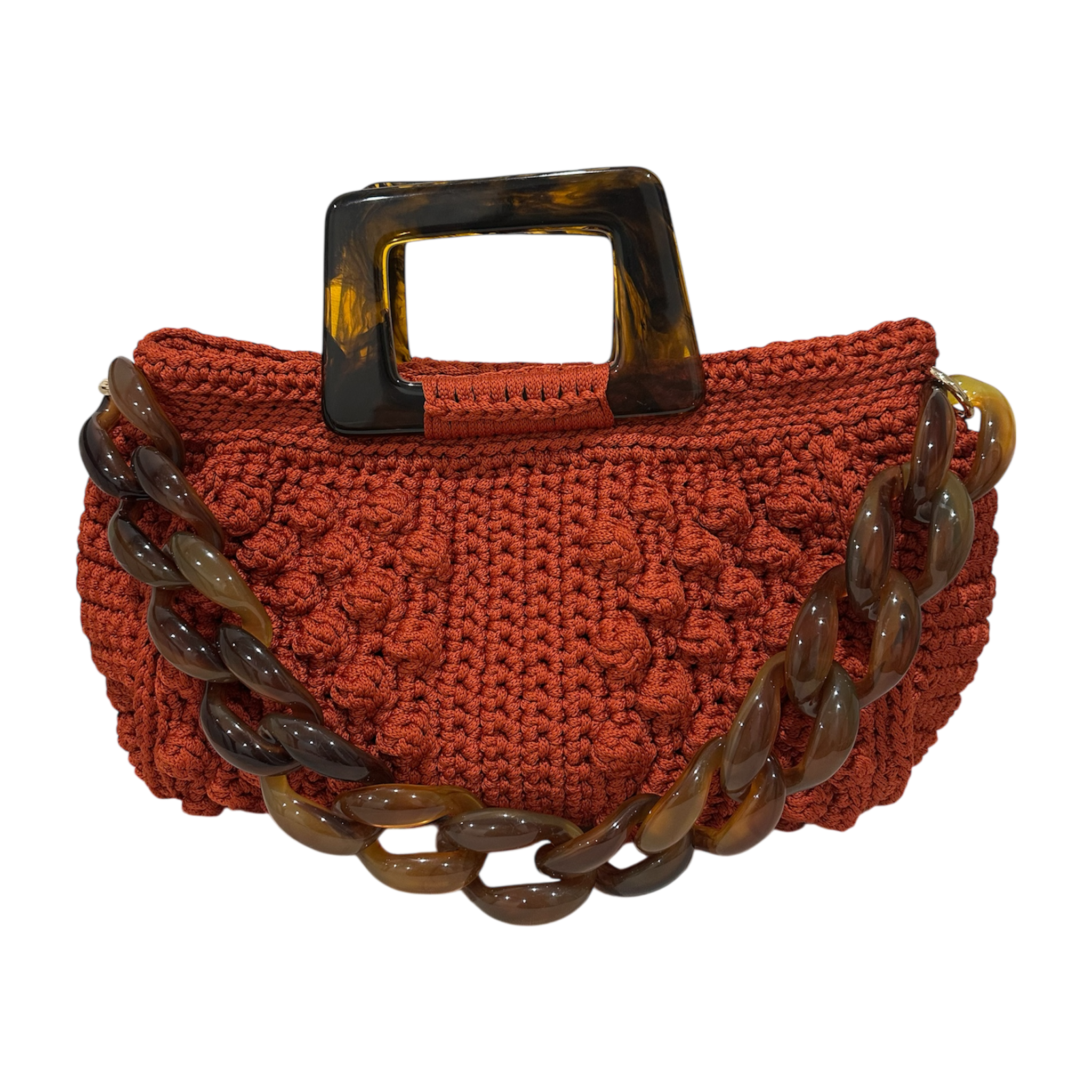 Hand-crocheted Paloma handbag in a burnt terracotta tone with dimensional textured stitching, featuring a marbled amber resin top handle and a coordinating chain strap.