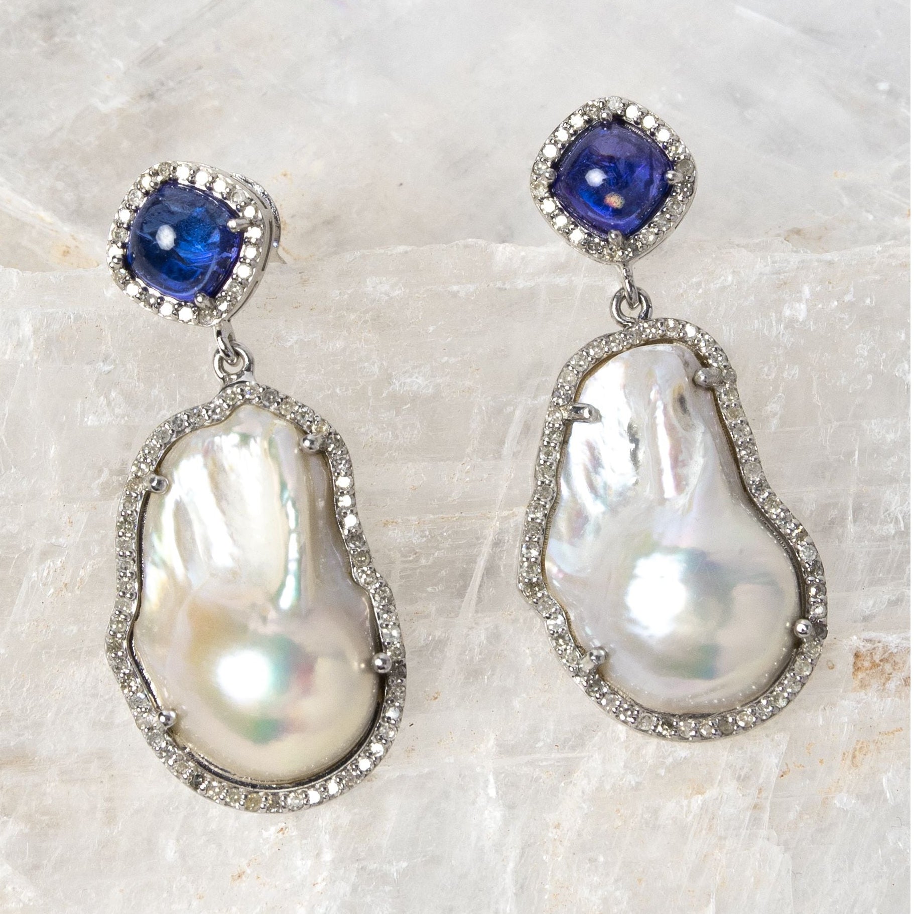 The Empress earrings featuring 4.30 carats of natural tanzanite, 0.90 carats of diamonds, lustrous baroque pearls, and sterling silver in an elegant statement design.