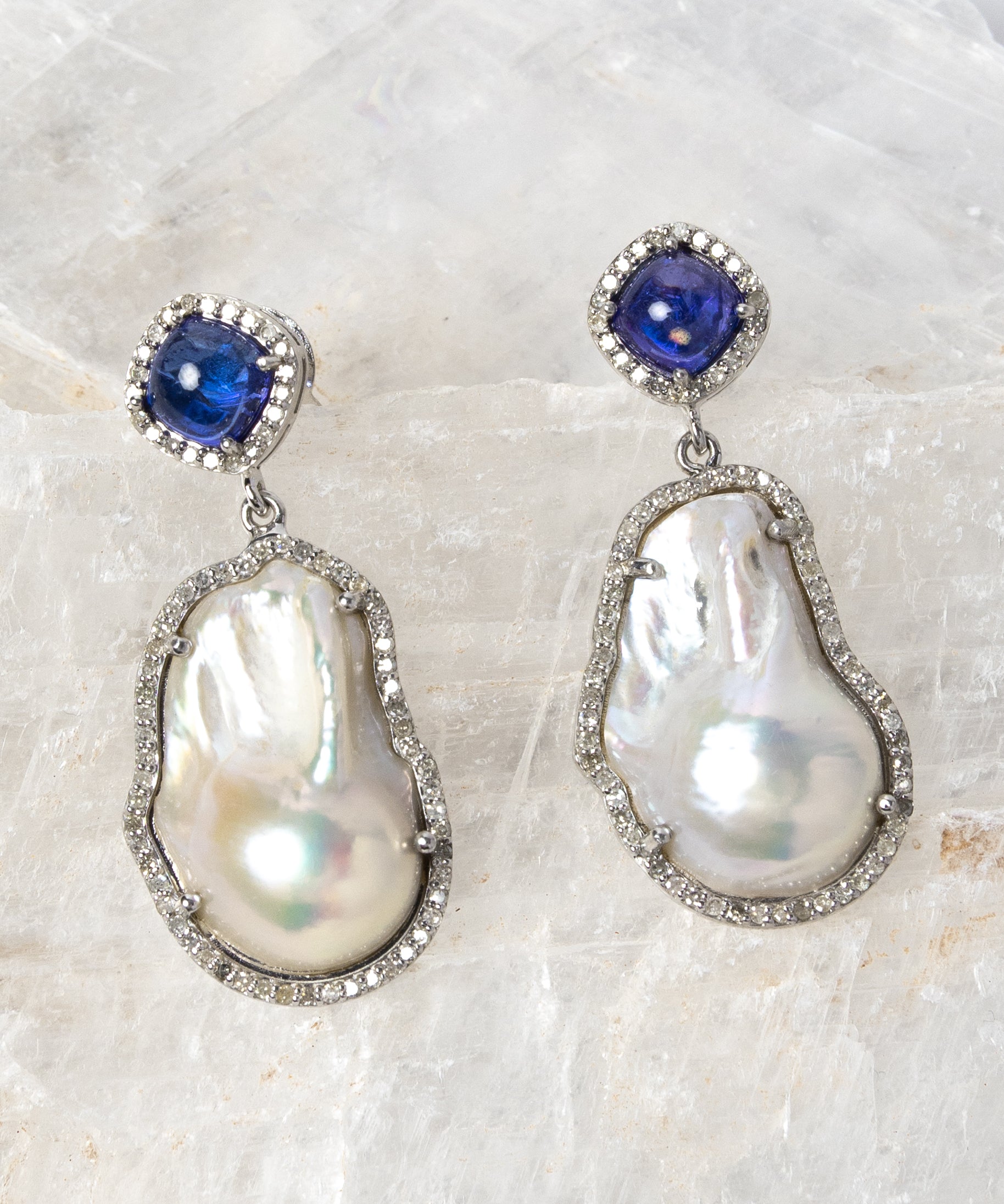 The Empress earrings featuring 4.30 carats of natural tanzanite, 0.90 carats of diamonds, lustrous baroque pearls, and sterling silver in an elegant statement design.