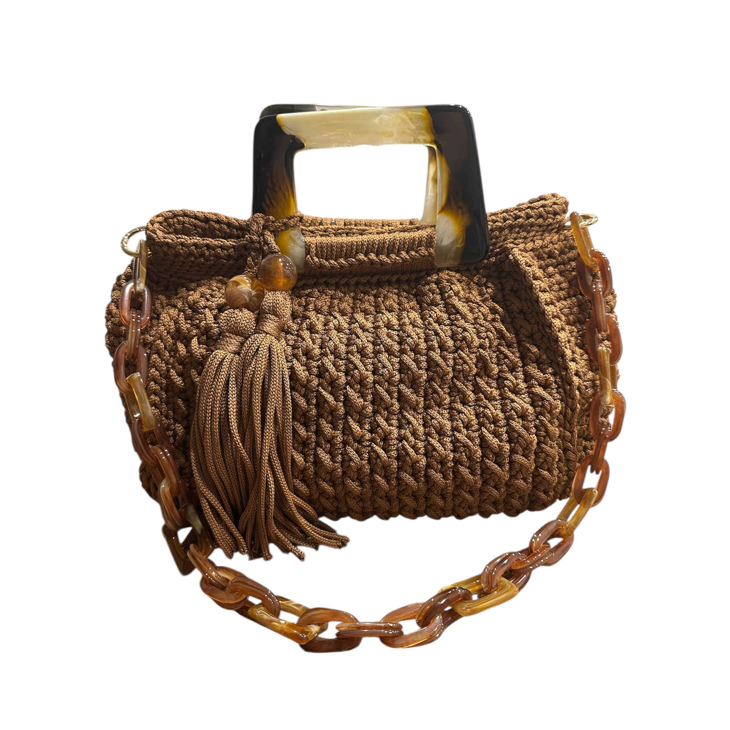 Hand-crocheted Giselle handbag in a warm cognac tone with dimensional vertical textured stitching, featuring marbled amber resin round handles and a coordinating chain strap.