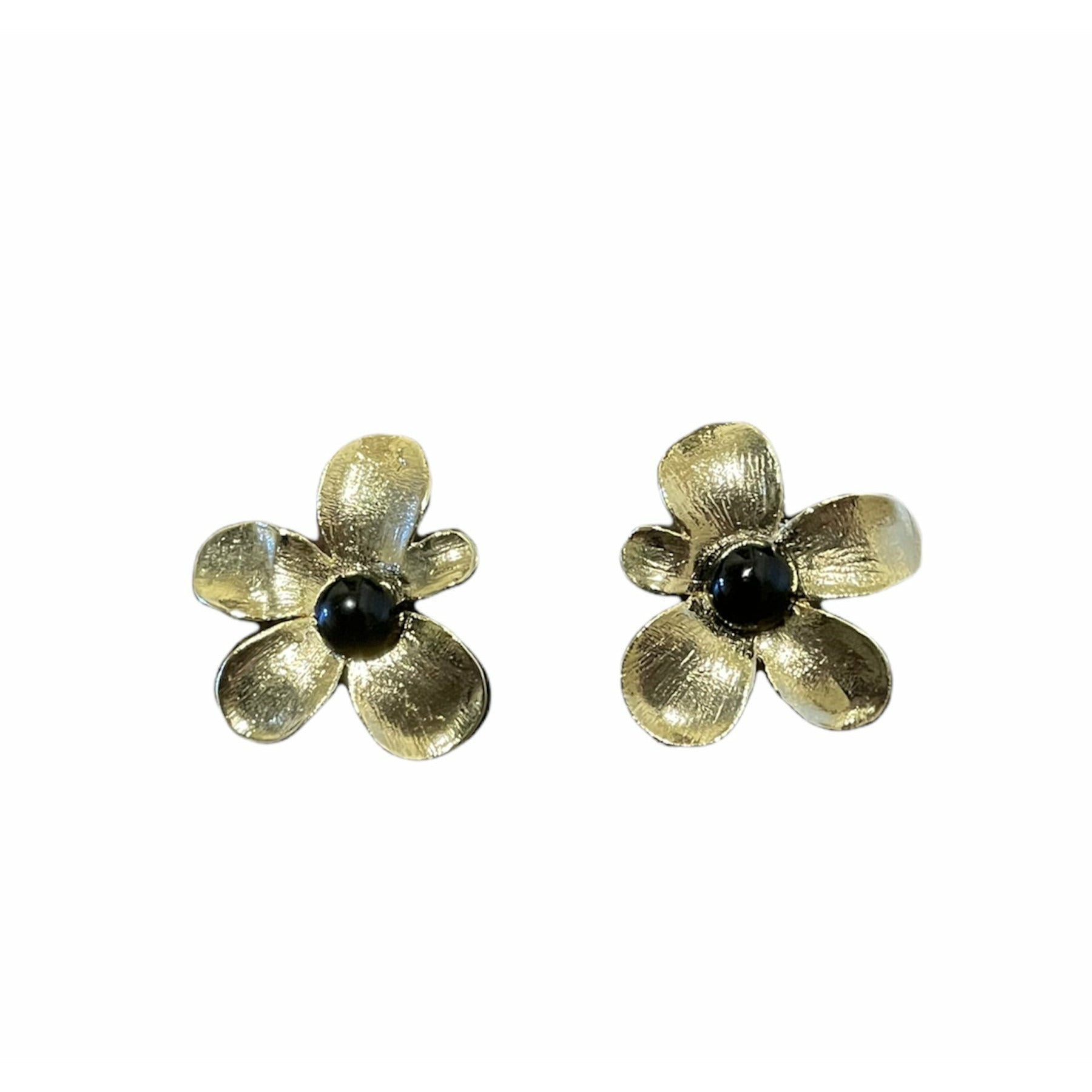 Romantic floral earrings featuring brushed gold-plated petals surrounding polished black onyx cabochons in a soft sculptural flower design.
