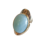 Allure statement ring featuring a natural 25 × 18 mm amazonite cabochon with soft seafoam and tranquil blue-green hues in a sculptural gold-plated setting, ergonomically designed for exceptional comfort.